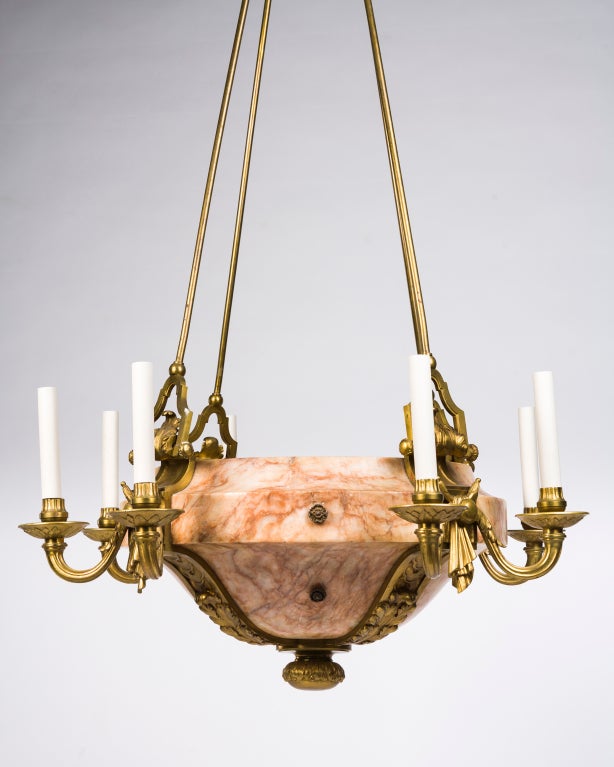 AHL3684
A massive marble inverted dome sixteen-light chandelier having four foliate-detailed cast bands from which the arms spring, supporting cast bobeches and cups. In its original aged bronze finish. Lamping at the center of the dome illuminates