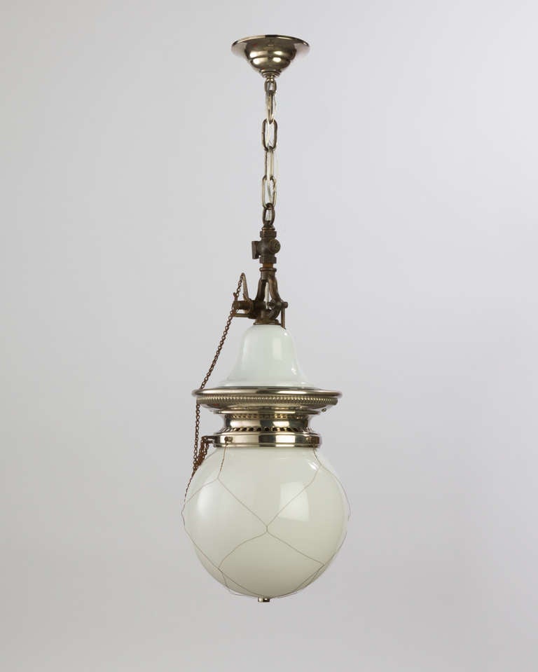 AHL3747

An antique pendant with white enamel and polished nickel fittings. The opal glass shade retains its original woven wire safety netting. Converted to electricity from gas, maintaining the original rocker ignition switches. Due to the