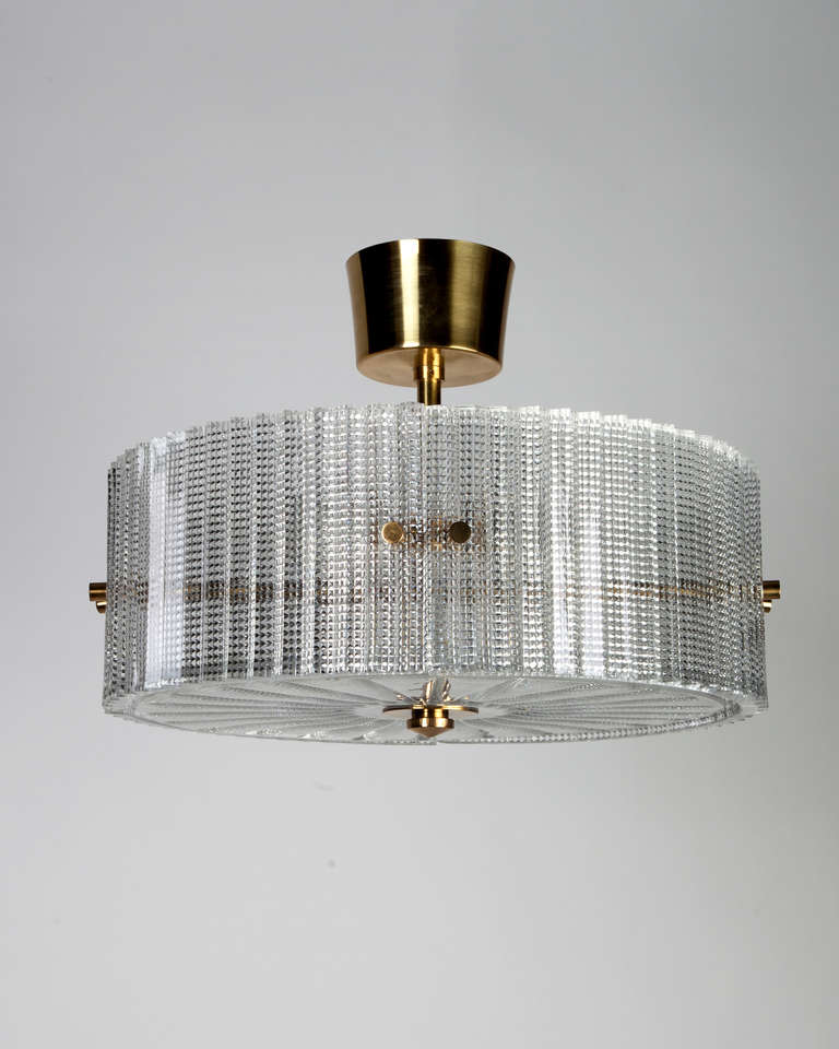 AHL3820

Circa 1940
A pendant with textured curved glass panels and diffuser on a frame in its original brass finish. Signed by Carl Fagerlund for the Swedish glassmaker Orrefors. Due to the antique nature of this fixture, there may be some nicks
