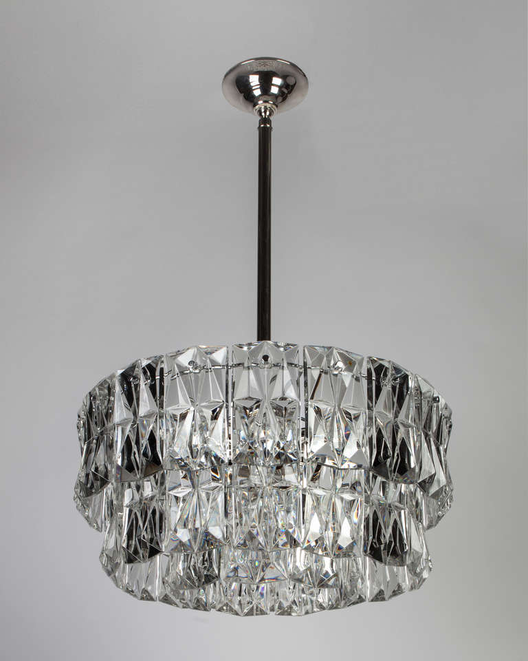 AHL3827

Circa 1960
A three-tier chandelier with faceted rectangular cut glass crystal pieces on a chrome and nickel frame. Attributed to the Austrian maker Kinkeldey. Due to the antique nature of this fixture, there are some nicks or