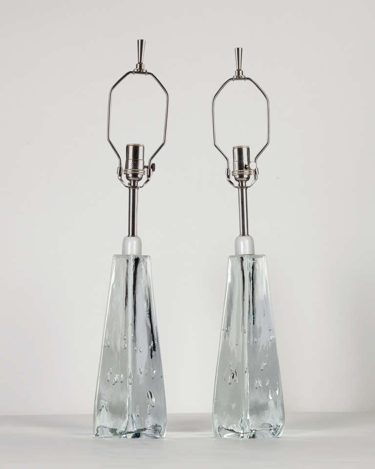 ATL1872

Circa 1960
A pair of clear solid Swedish glass table lamps with polished nickel fittings. Due to the antique nature of this item, there may be nicks and imperfections in the glass as well as variations from piece to