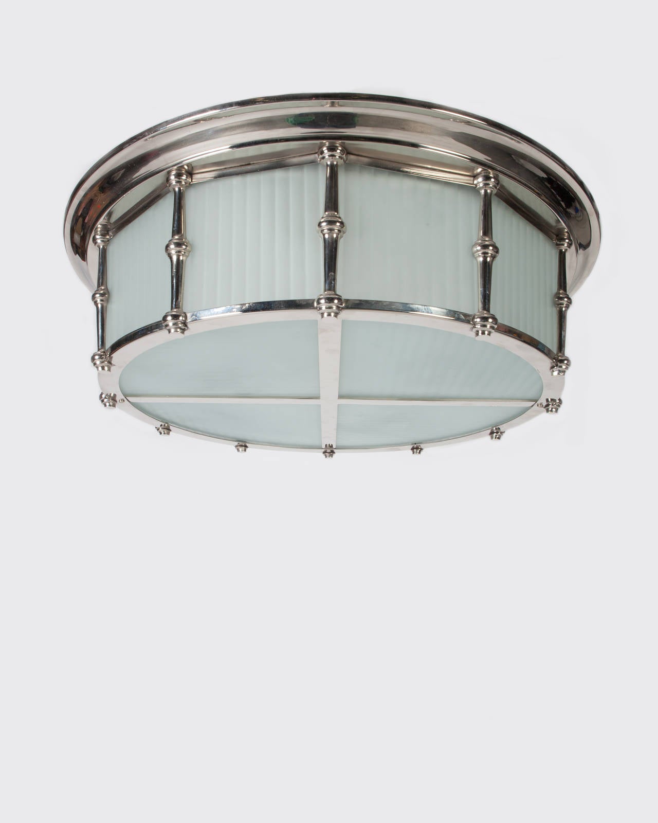 AHL3916.

circa 1930.
A large Art Deco period flush mounted fixture with frosted fluted glass panels in a nickel finish. Due to the antique nature of this fixture, there may be some nicks or imperfections in the glass as well as variations from