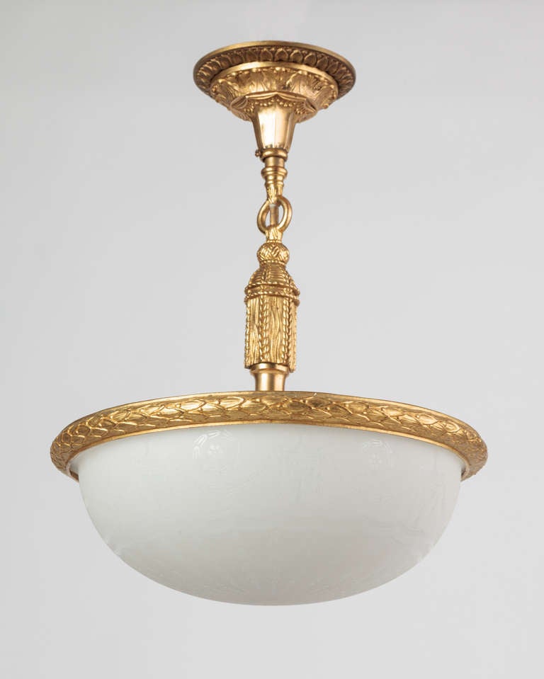 AHL3772

An antique inverted dome chandelier having a lens of cased glass etched with a pattern of urns, swags, and bellflowers held in gilded laurel banding from a tasseled stem. Due to the antique nature of this fixture, there are some nicks or