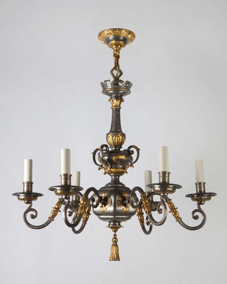 AHL3833<br />
<br />
A six light chandelier finished in dark pewter with gilt brass details. The rough modeling and surface of the pewter areas contrasts well with the fine chasing and crisp details of the gilding. Attributed to the New York maker