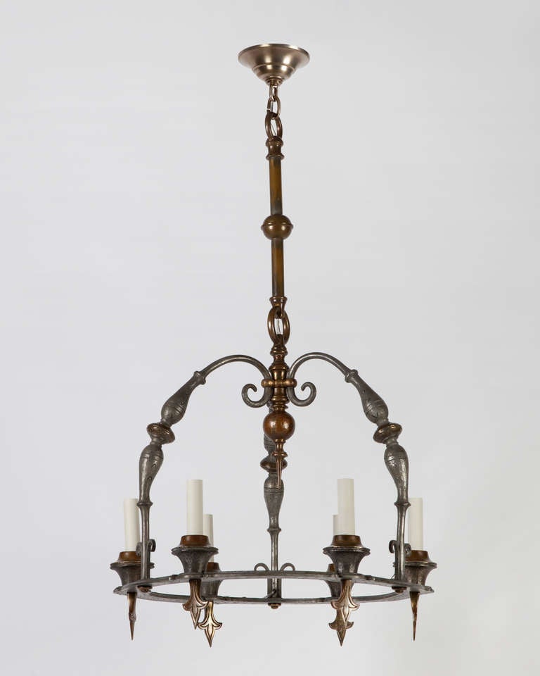 AHL3839
A wrought bronze six light hoop chandelier in its original weathered nickel and brass finish, having muscular proportions and a chiseled and hammered surface with scroll and fleurs-de-lis details. From a Duchess County, New York estate.