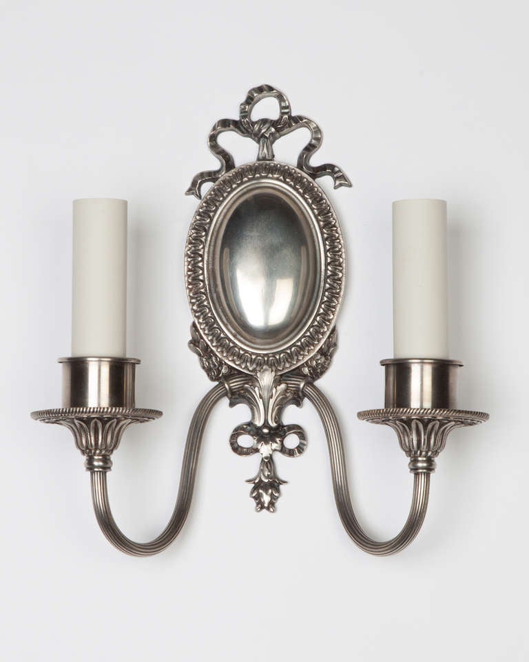 AIS2893

A pair of double light sconces with foliate and ribbon and bow details in an aged nickel finish. By the New York maker Sterling Bronze Co. 

Dimensions

Overall: 10