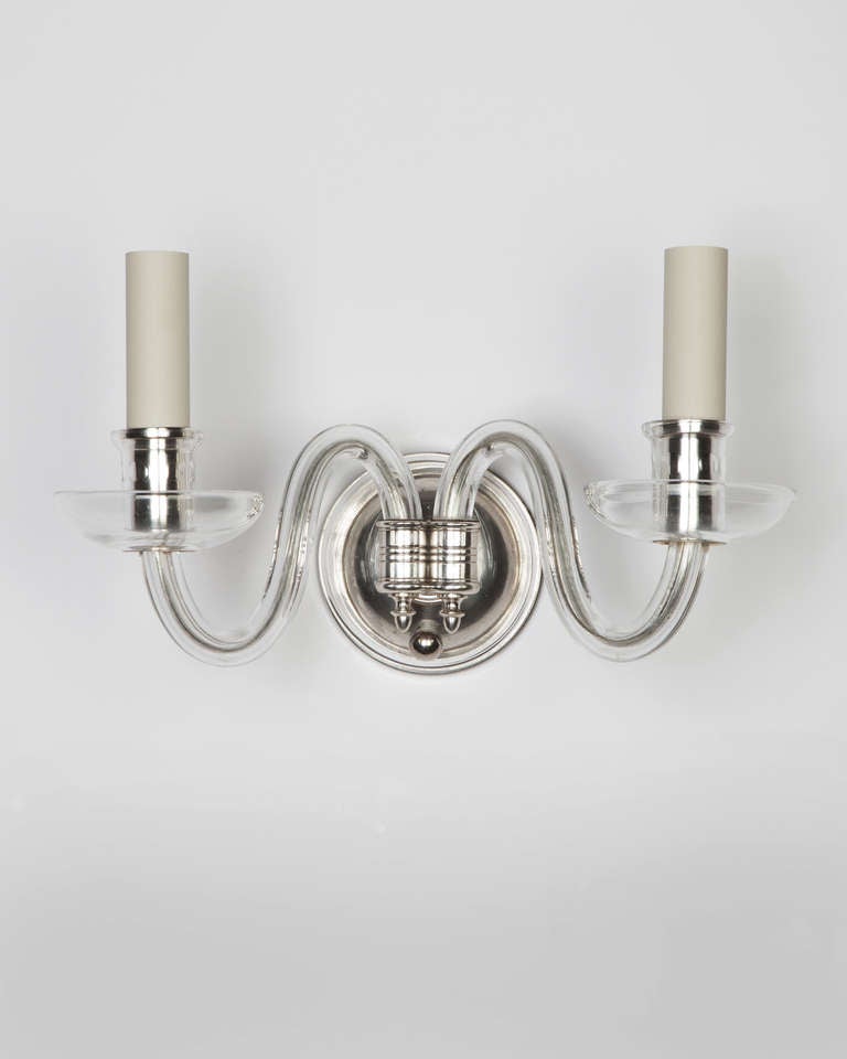 AIS2894

A pair of double light sconces in their original silver plate over brass finish, having crystal arms, cups, bobeches and backplates. Due to the antique nature of this fixture, there may be some nicks or imperfections in the glass.