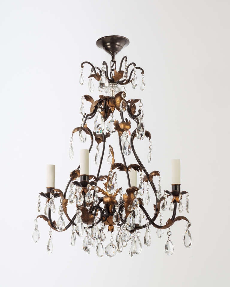 AHL3775

An antique four light brass chandelier in a black enamel finish with gilded foliate details dressed with prisms.

DIMENSIONS
Current height: 63