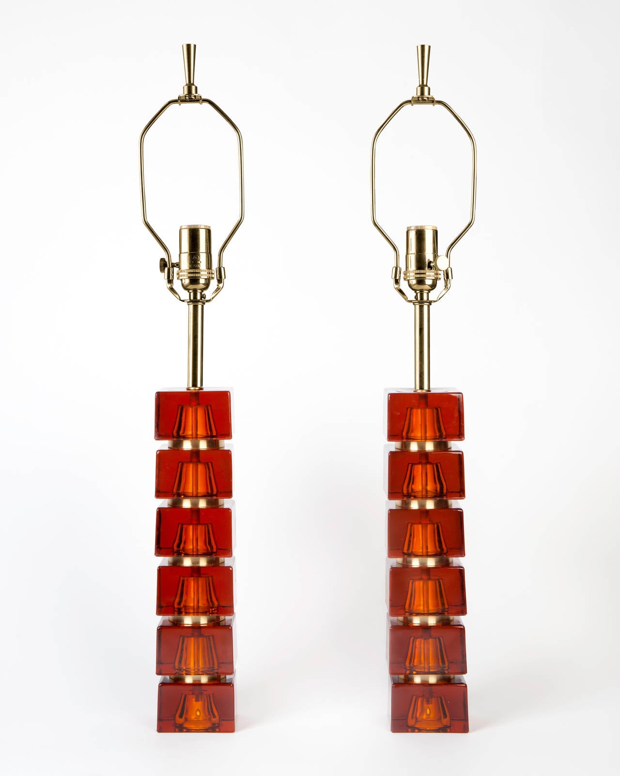 ATL1899

A pair of "stacked" lamps made of alternating brass discs and squared orange glass pieces. By Carl Fagerlund for the Swedish maker Orrefors. Due to the antique nature of this fixture, there may be some nicks or imperfections in
