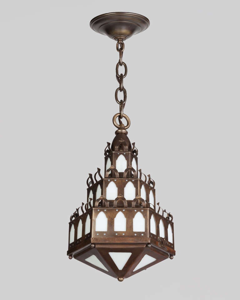 An antique lantern in a great aged brass finish. Each tier is pierced with gothic arched windows, glazed with milk glass panels.

Dimensions:
Current height: 53-1/2