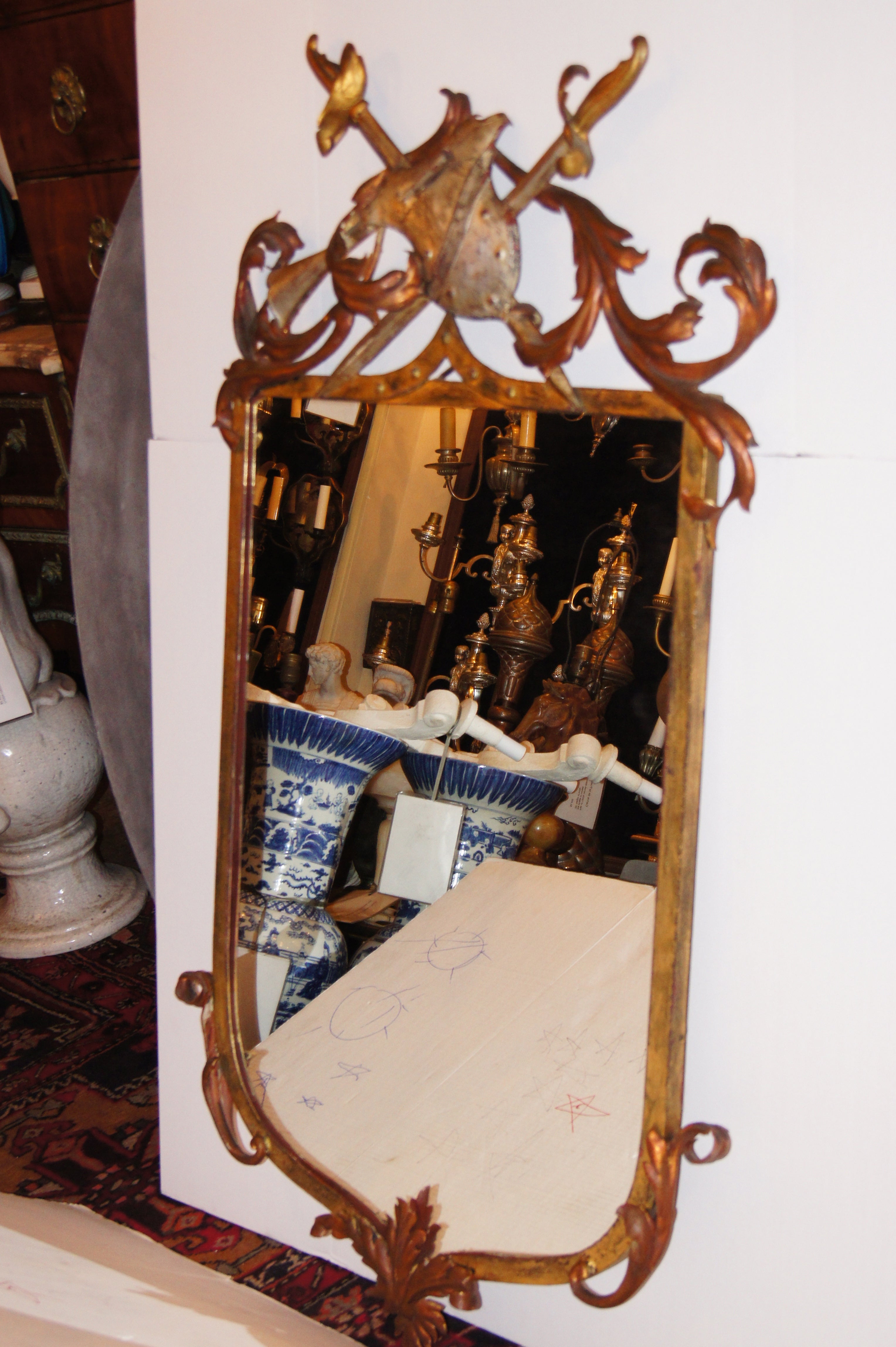 A circa 1940's Italian gilt and silver leaf metal mirror with armorial motif on crown and foliage decoration on frame.

Measurements:
Height: 55