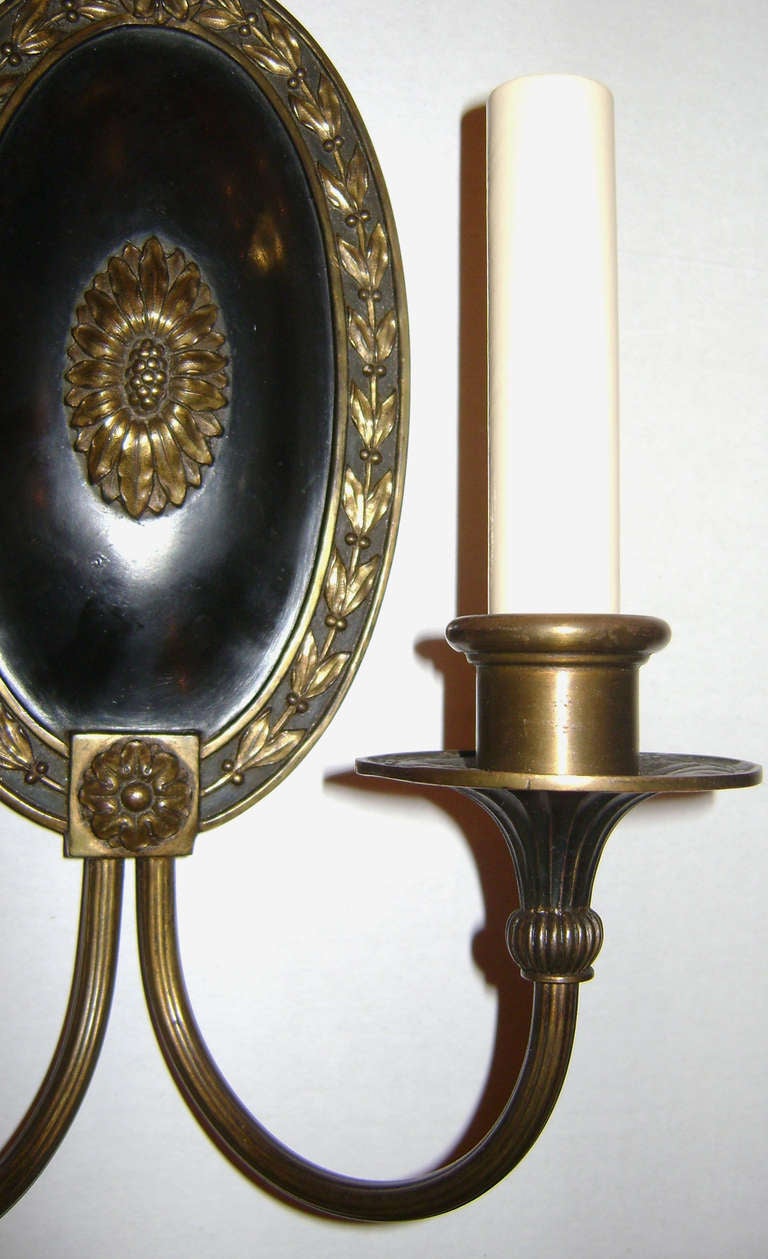 Pair of 1920s neoclassic style American sconces with painted backplate and original patina.

Measurements:
Height 10.25