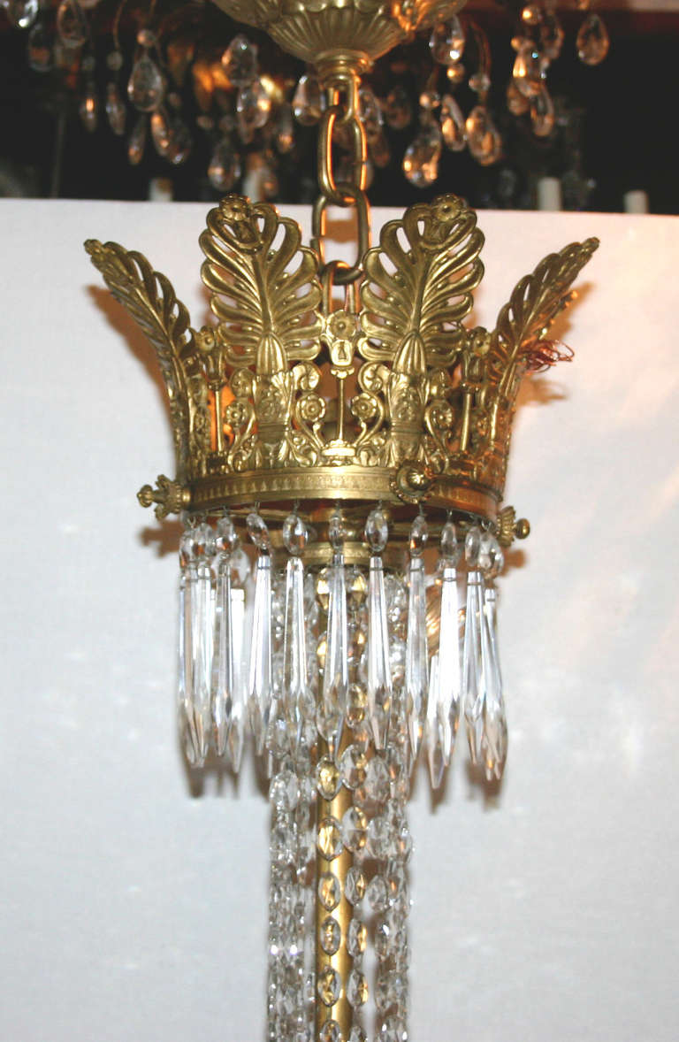 French, mid 19th Century Empire style bronze chandelier with crystals.  Elaborate foliage motif decoration on body and crown.
12 interior lights.
