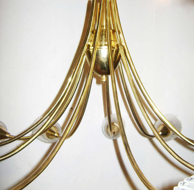A circa 1960's Swedish gilt brass and molded glass twelve arm chandelier.

Measurements:
Height: 18″
Diameter: 33″