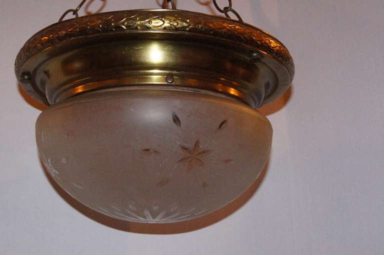 An Italian pendants light fixture with glass inset with etched stars on body, circa 1920. Neoclassic style.

Measures: 14.5" diameter, 12" min. drop.
