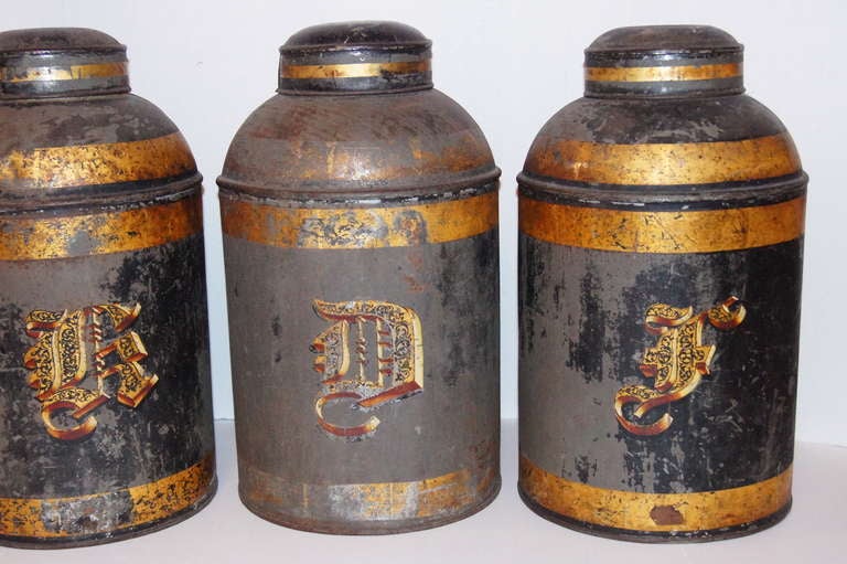 Set of three, English, 19th century tole canisters with painted and gilt finish, original patina. 
18