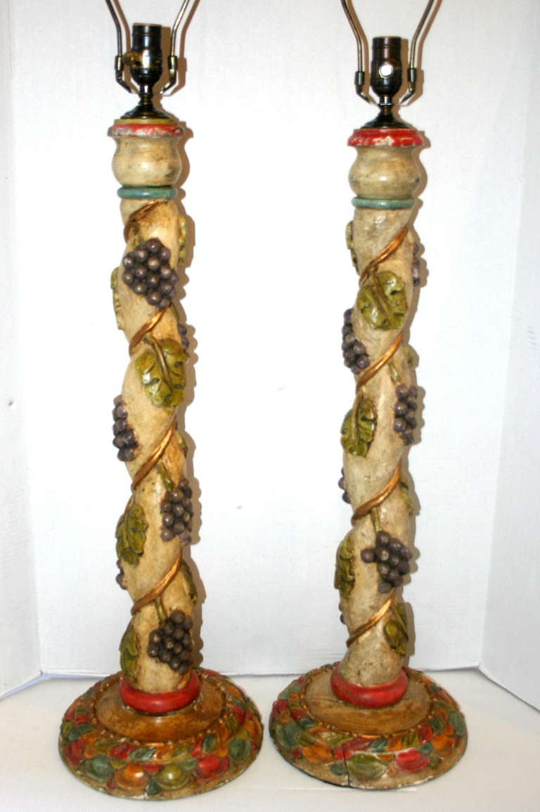 A pair of  Spanish 1920s carved wood candlestick lamps with a grapevine motif.

Measurements:
Height of body 30