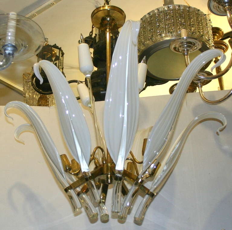 A circa 1960's Murano glass light fixture with 8 lights. The arms shaped as elongated leaves in a milky white glass with clear glass accents. body with 3 cat tail flower decorative pieces.

Measurements:
Height: 32