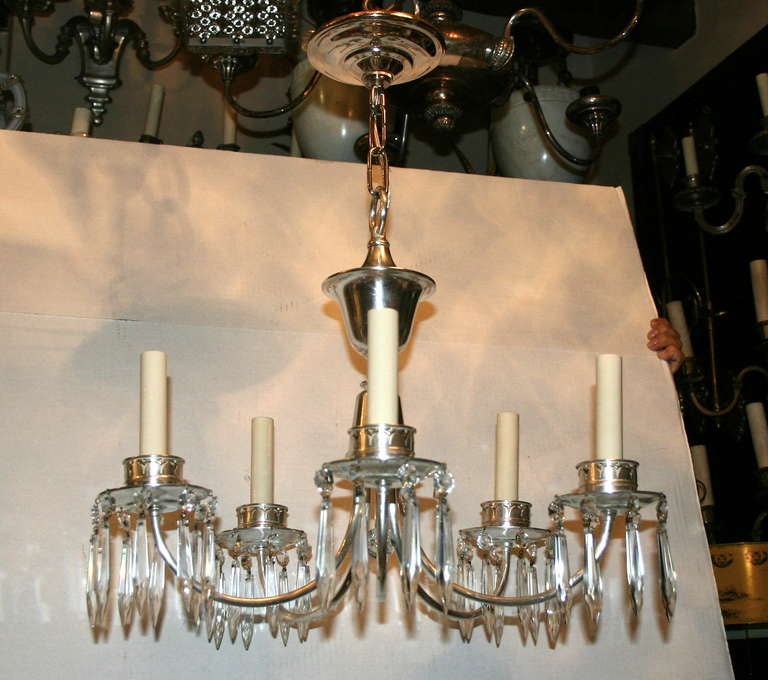 English silver plated neo Classic style chandelier with five lights and with crystal drops, circa 1920s.