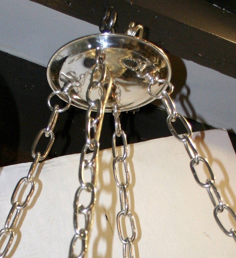 Pair of 1930s American silver plated 8 lights chandeliers of neoclassic style, with 4 chains supported by handles.
30″ drop, 21′ diameter