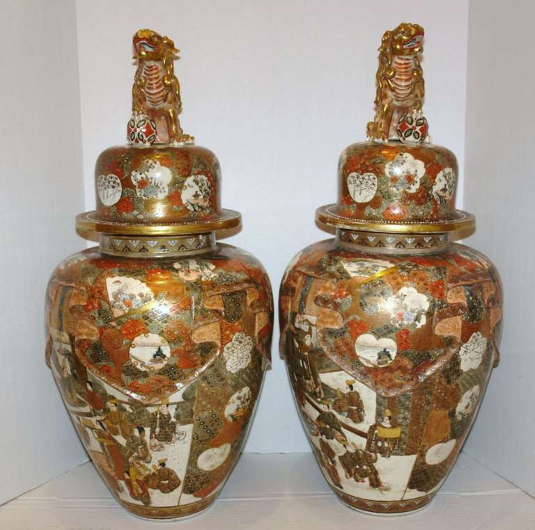 Pair of 19th century Japanese vases with Foo Dogs on lids. The body with design of fabric wrapped around the top. Gilt and polychromatic decoration. 

Measures: Height: 27 in.
Diameter: 13 in.