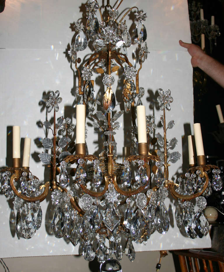 A French, circa 1930s gilt metal Bagues chandelier with molded glass leaves and crystal flower. Eight candelabra lights.