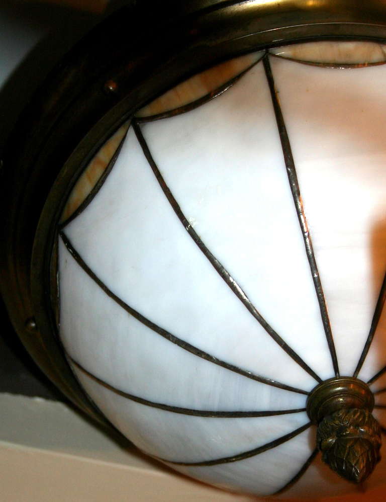 A circa 1930's flush-mounted neoclassic style leaded glass light fixture with interior lights.

Measurements:
Diameter: 17.5