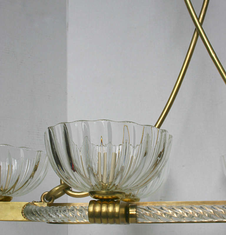 A circa 1940 Murano horizontal chandelier with oversized glass bobeches and gilt body. Eight lights. 40