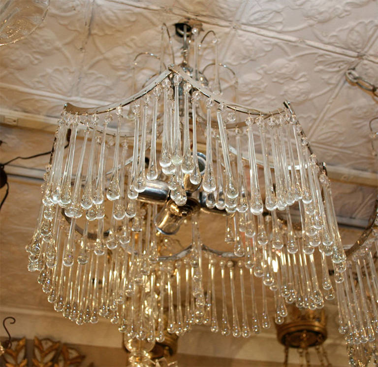 Coppia di apparecchi di illuminazione italiani degli anni '50 placcati in argento con pendenti a goccia in vetro e con luci interne.

Altezza: 23,5 pollici.
Diametro: 18 pollici.