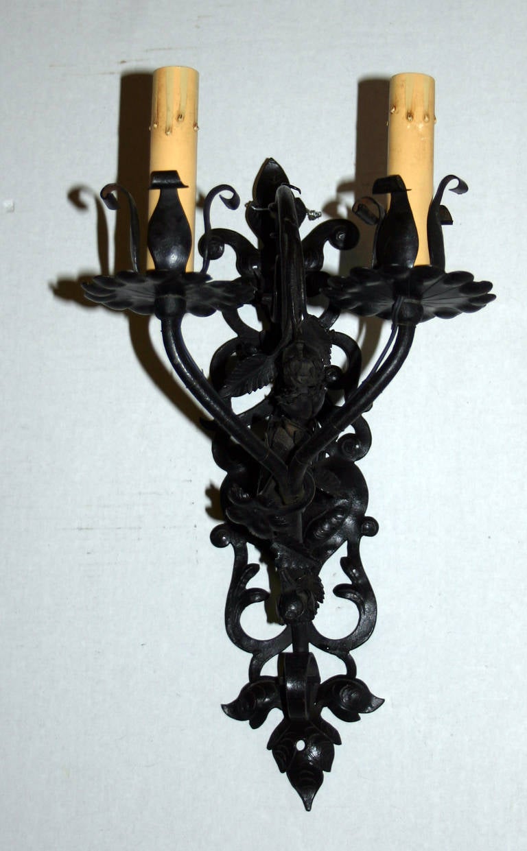 A pair of, circa 1940s French wrought iron sconces with foliage design, double arms.