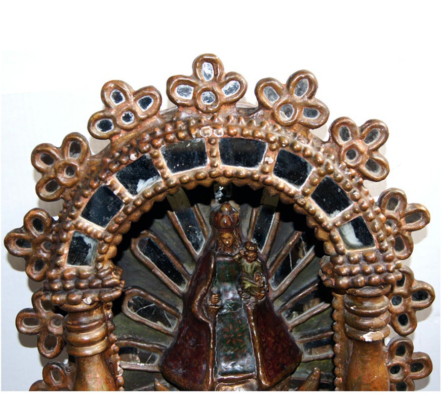 A 19th century Spanish colonial altar of Virgin and child with mirror insets. Piece with original patina. Some mirror pieces show small cracks, consistent with age. The base with angels on clouds. Crown of piece with floral motif.