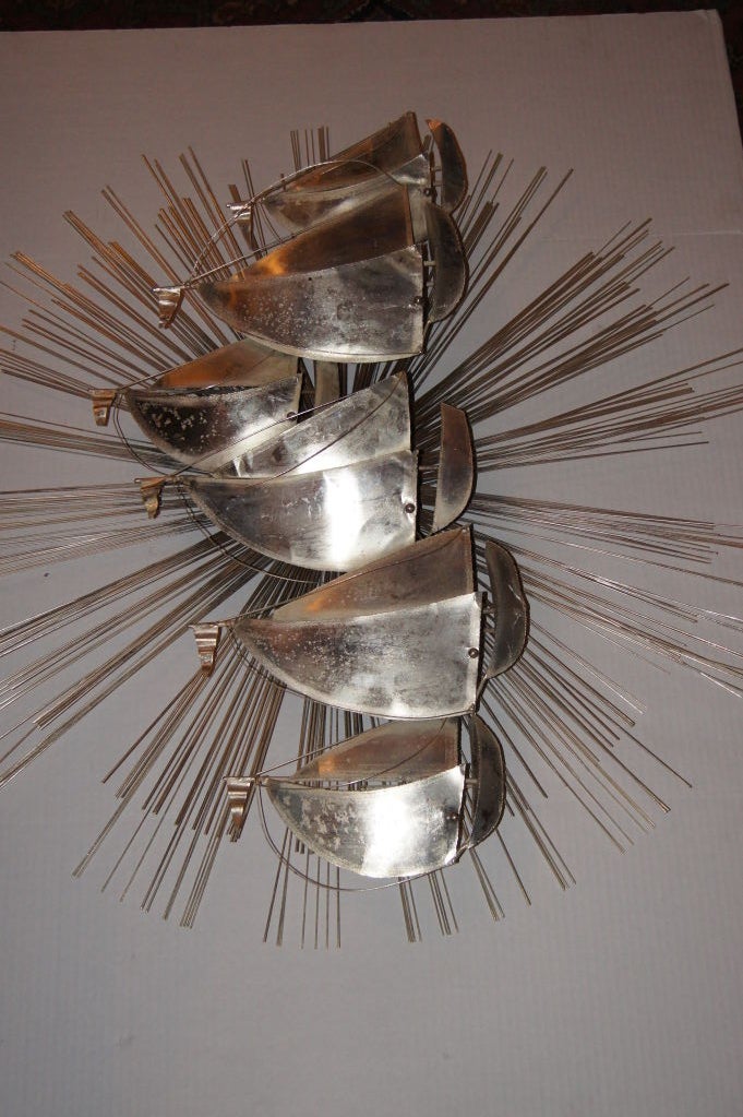 An Italian silver plated wall sconce shaped as a sunburst with sail boats and with one-light behind each sail. Six lights total.

Measures: 36" height, 36" wide.

 