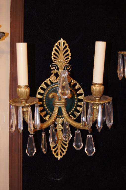 Pair of 1930s French Empire style double light sconces, foliage details on body and with crystal pendants.

Measures: 12.5