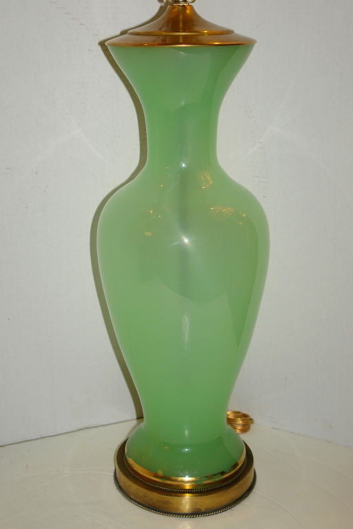 A single 1930's French green opaline glass table lamp with gilt details.

Measurements:
Height of body: 23.5