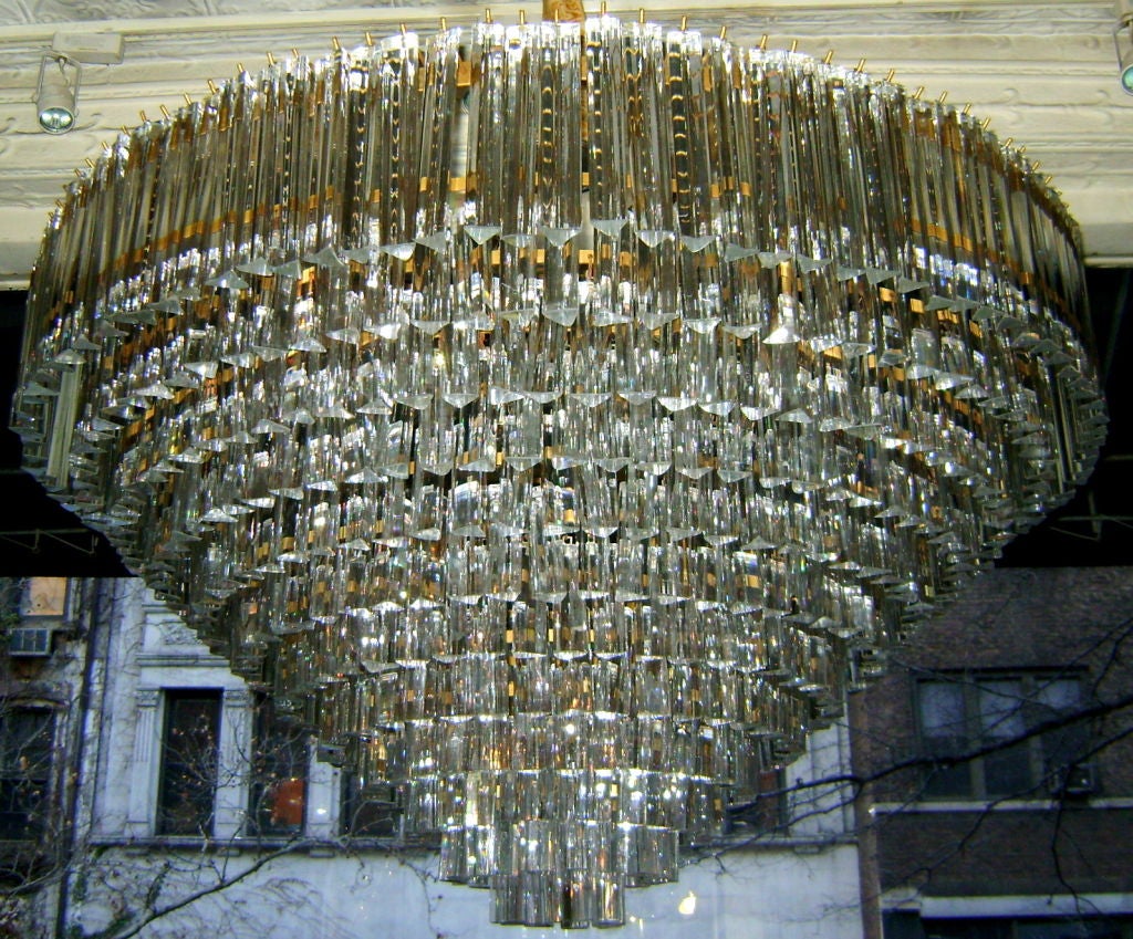 A pair of large, 1960s, Italian Venini glass light fixtures with 30 interior lights each. The glass in a cascading pattern suspended from a silver body.