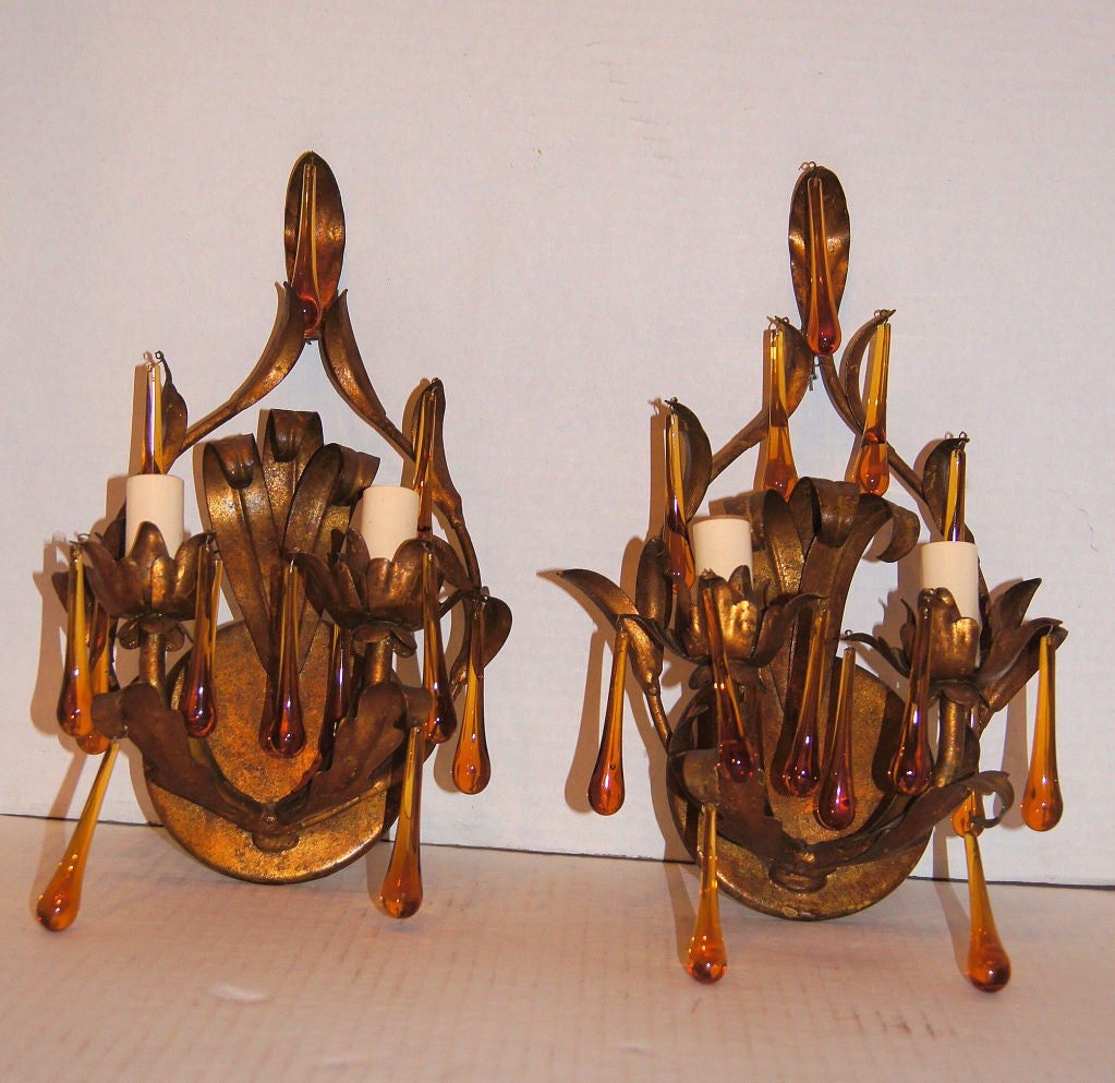 Pair of gilt metal, double light sconces with amber colored glass drops.

Measures: 14