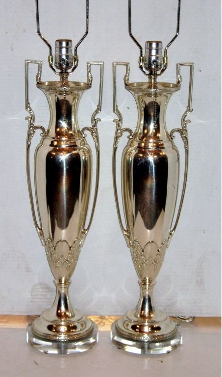 Coppia di lampade da tavolo inglesi in stile neoclassico placcate in argento del 1940 circa con basi in lucite.

Misure:
Altezza del corpo: 22