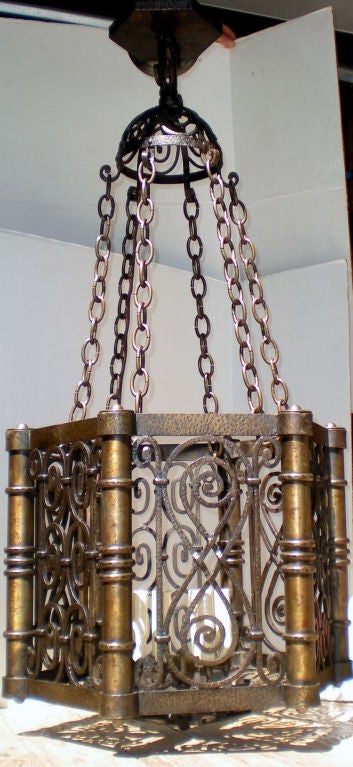 An English, hammered bronze lantern of open work design and six lights, circa 1920.