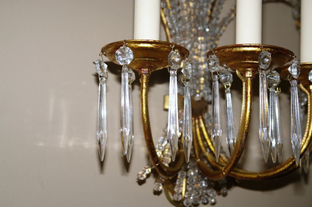 Paar französische Wandleuchter aus vergoldetem Metall und Kristallperlen aus den 1950er Jahren mit vier Lichtern. Körper mit Perlen und Kristallblumen.
   