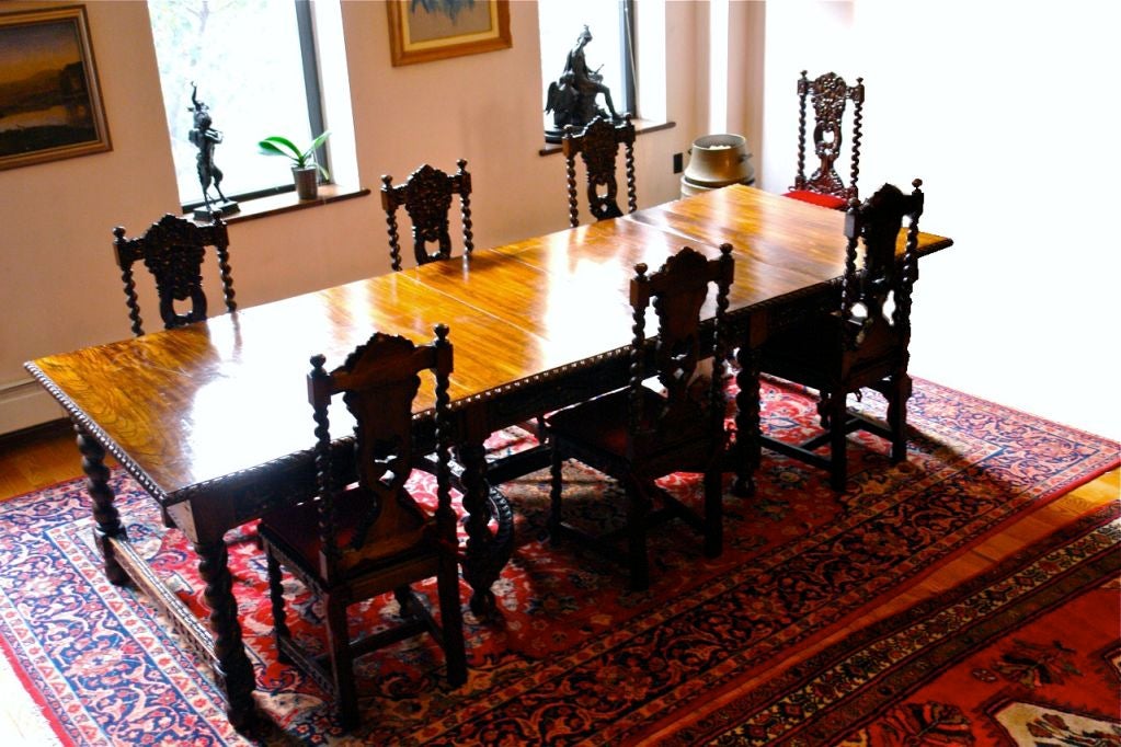 Large Spanish carved dining table with 3 extension leaves and 12 carved chairs with red velvet cushions.

Open Table:
10 feet 5