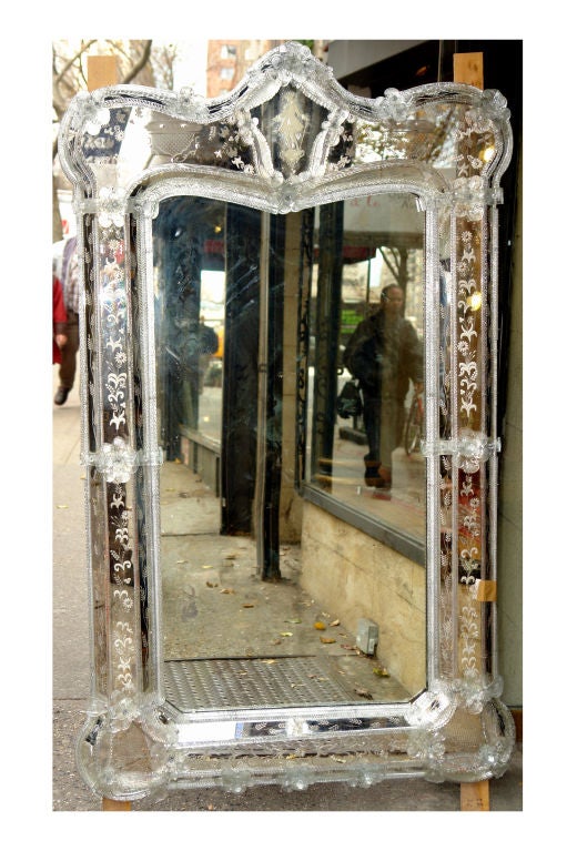 Pair of large 19th century Venetian mirrors with etched details on sides and crowns. The tops decorated with the image of a lady and a gentleman each. The frame and crown with foliage and floral motif applied decoration supporting the mirror insets.