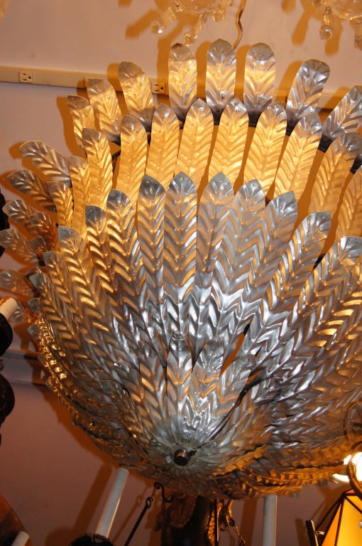 Coppia di lampadari oversize italiani, anni '40, con luci interne. Corpo a forma di fogliame placcato in argento. 12 luci interne.
Misure: Diametro 36
