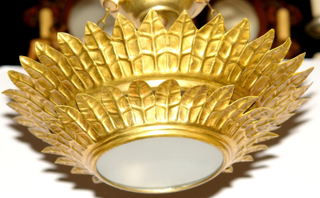 Set of 15, circa 1940s Italian gilt metal, double-tiered sunburst light fixtures with interior lights and frosted glass inset. Sold individually.

Measurements:
Diameter: 13.5