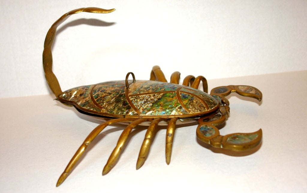 A brass scorpion with inset mother-of-pearl. The body is a lid that opens up, circa 1960s.