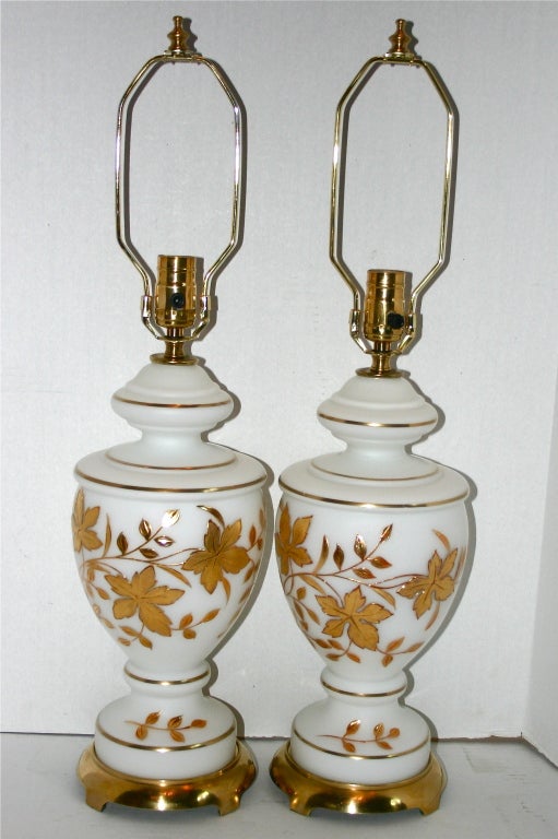 Pair of circa 1940's opaline glass lamps with gilt floral decorations.

Measurements:
Height of body: 15.5
