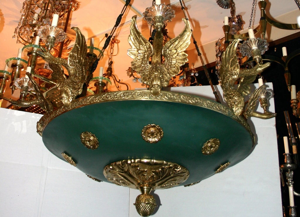 A very unique and impressive vintage cast bronze Empire style gilt bronze and painted tole chandelier with swans shaped arms. The large body with rosette insets. Eight lights.
Measures: 
52