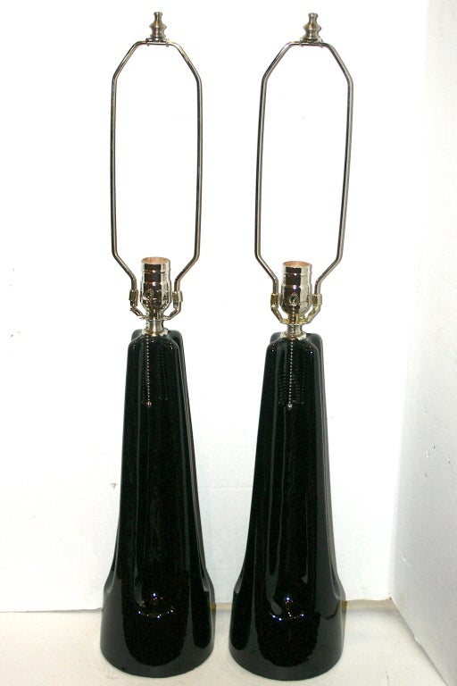 Paire de lampes de table italiennes en porcelaine noire datant des années 1950, avec des détails festonnés sur le corps de la colonne cannelée.

Mesures :
Hauteur du corps : 17