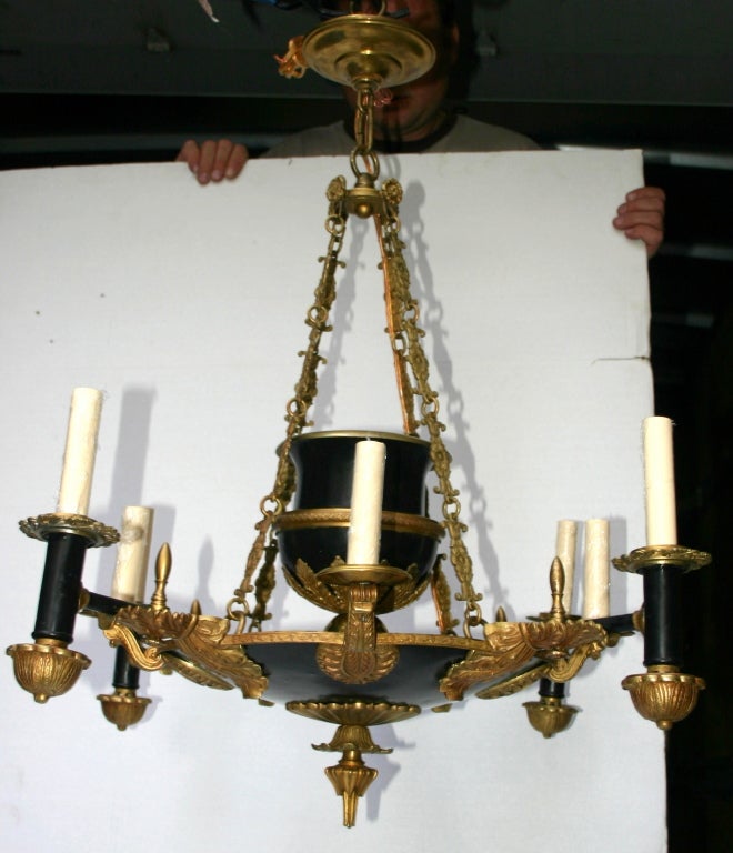 A turn of the century French Empire-style 8-arm chandelier with acanthus leaf motif on body and with painted and gilt finish.

Measurements:
Height: 30