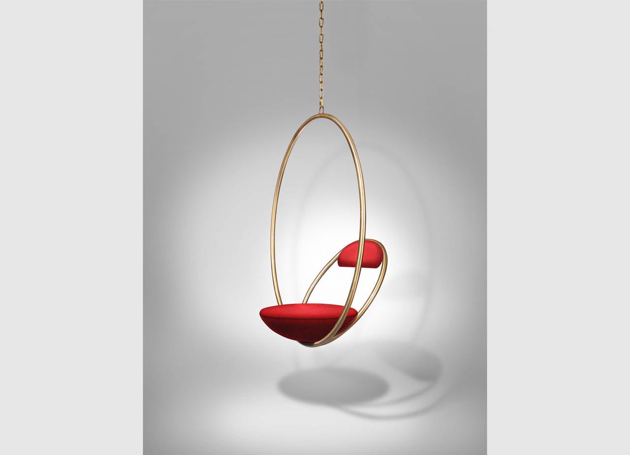 Suspended from above, two brass-plated steel circular hoops join to create the hanging hoop chair, with a seat and backrest upholstered in Kvadrat wool.