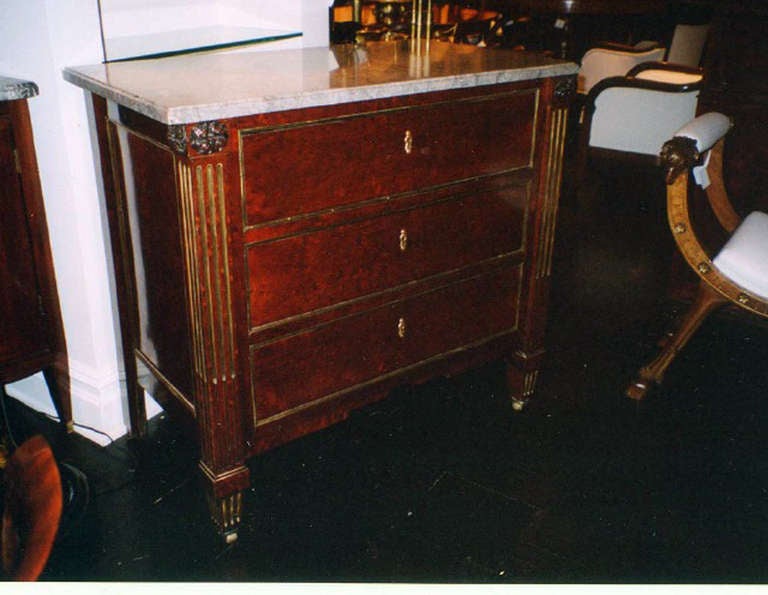19th century mahogany commode with mixed elements, grey marble top above three drawers within giltwood molding, flanked by parcel-gilt.